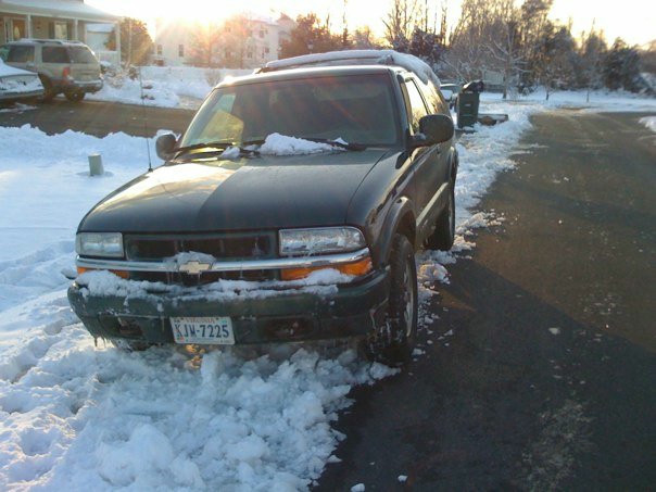 A green 98 Chevy Blazer covered in snow.