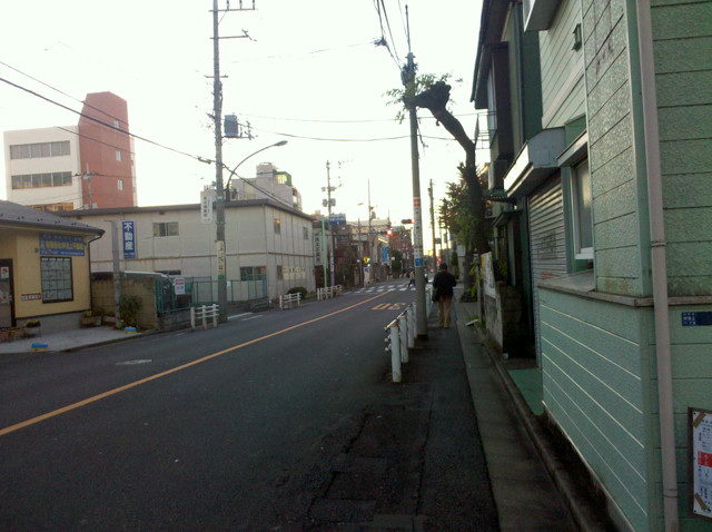 An early morning street in Tokyo. Only one other person is on the street.