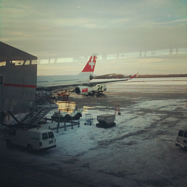 Looking out onto the tarmac at a Swiss Airlines plane.