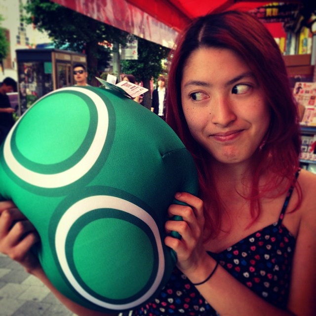 A woman hugs a puyo-puyo bean bag toy.