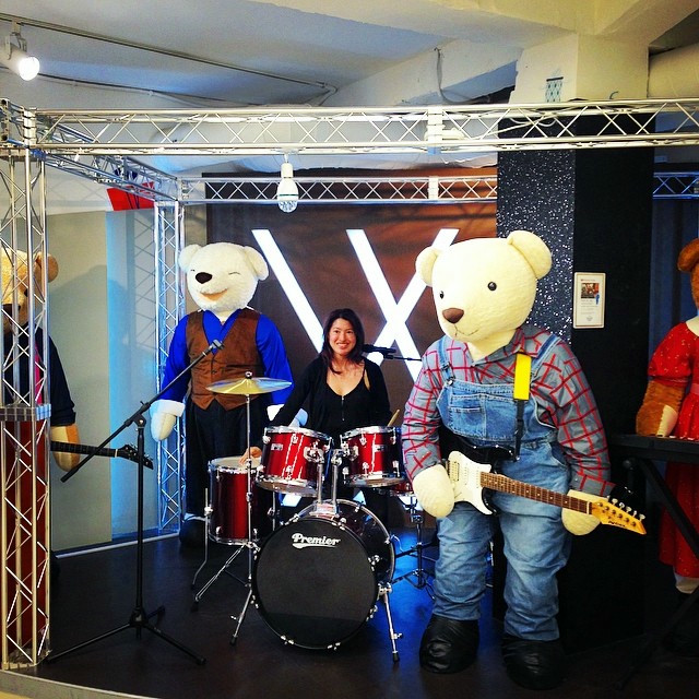 A woman sits in an animatronic bear band. It is as absurd as it sounds.