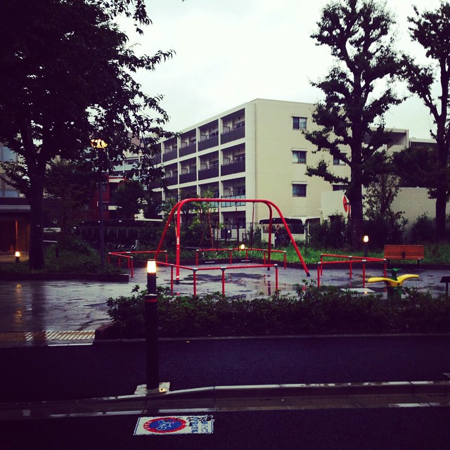 A striking red playground amidst some apartments.