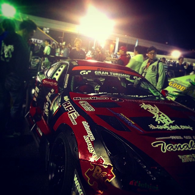 A red drift car, with crowds of people around.