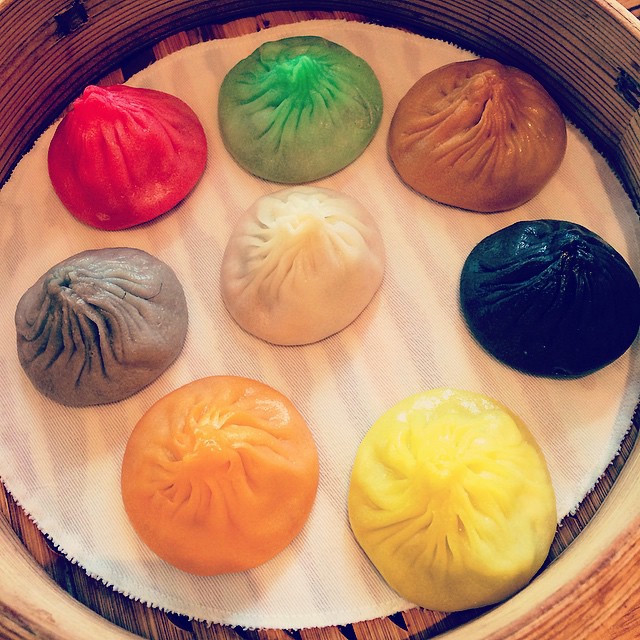 A basket of dumplings in an assortment of colors (red, green, orange, black, yellow, brown and green).