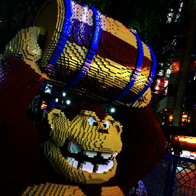 A Lego-like Donkey Kong statue, holding a barrel above his head.