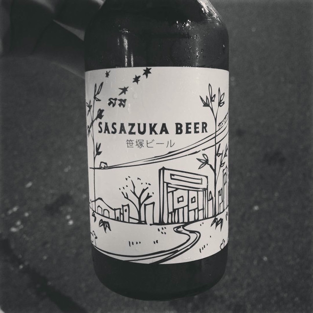 A bottle of beer with a line-art based design on it. The label says 'Sasazuka Beer'.