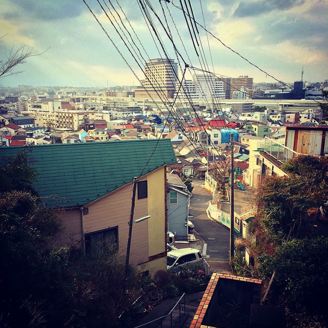 Looking over Yokohama from on top of a hill. A suspended train track runs through the shot.