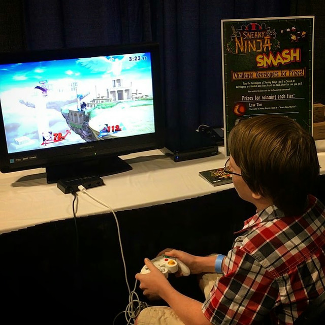 A boy playing Smash 4 on a TV.