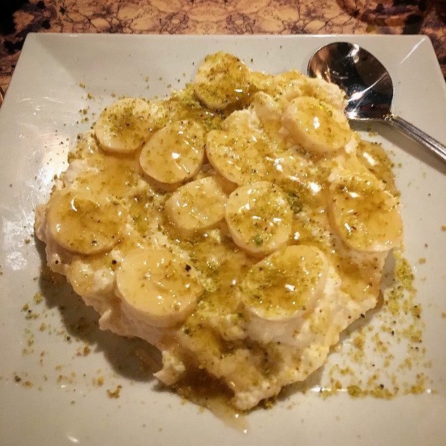 A dessert of bananas, pistachios, honey and rice pudding.