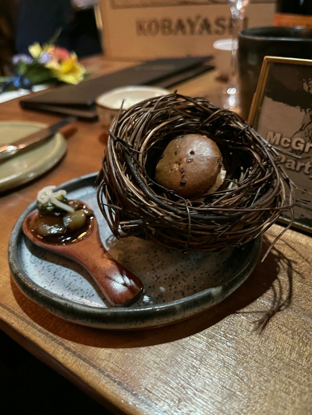 A savory brown macaron in a rendition of a birds nest.