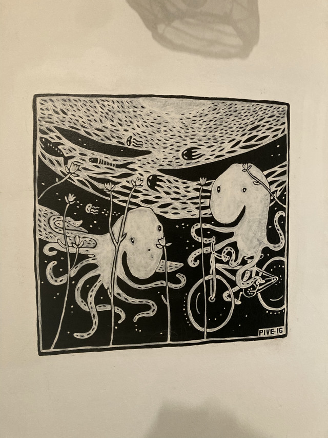 Two squid looking creatures floating in what appears to be space. The artwork is drawn on a white wall and is in black and white.