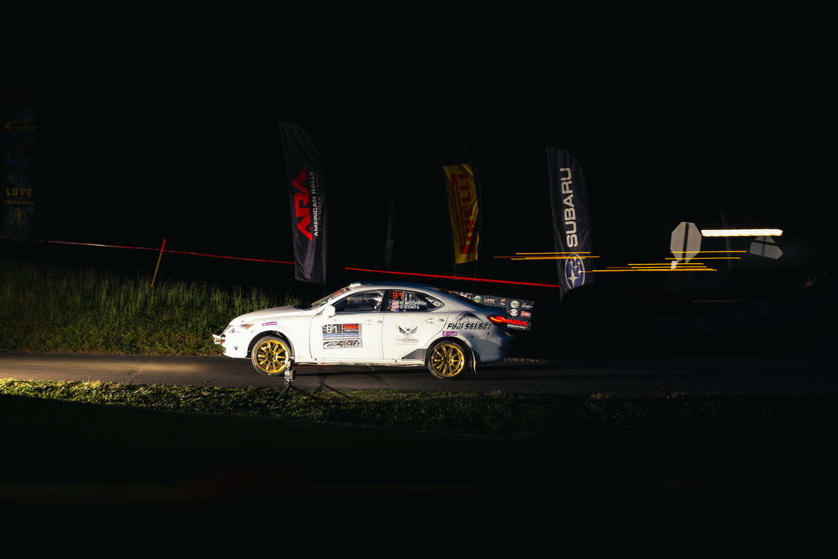 A white Lexus IS250 with gold rims races through the night.