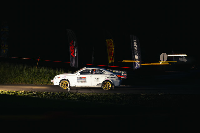A white Lexus IS250 with gold rims races through the night.