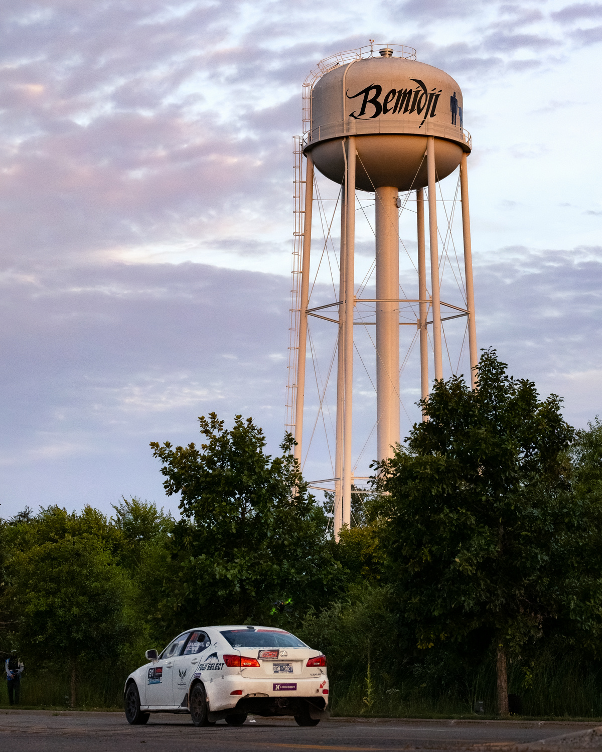 A white Lexus IS250 in front of a Bemidji water tower.