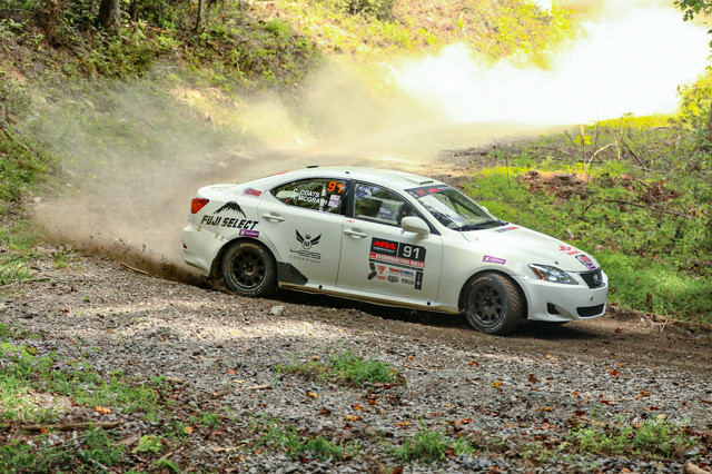 A white Lexus IS250 slides through a turn in the woods.